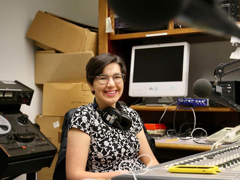 Young woman working at a radio studio board